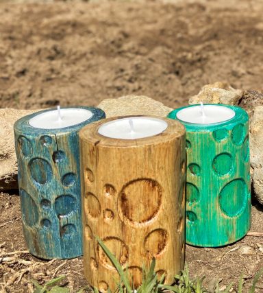 Tres velas decorativas de colores azul, dorado y verde formas circulares.